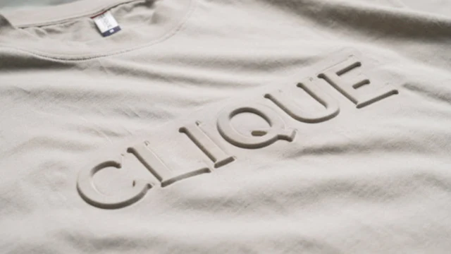 Beige t-shirt med ordet Clique präglat i relief i tyget