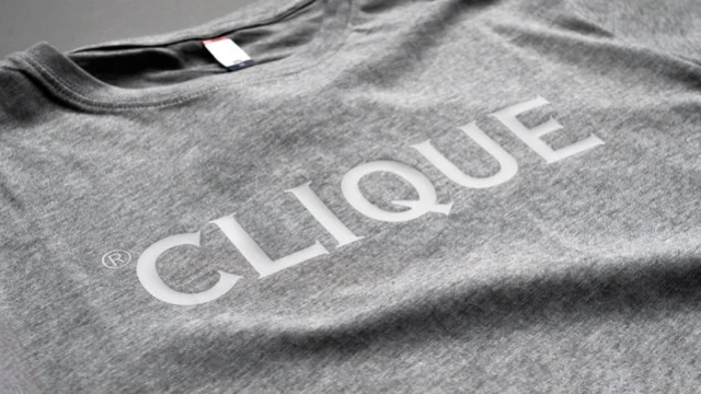 Grå t-shirt med ordet Clique tryckt i ljusgrått över bröstet
